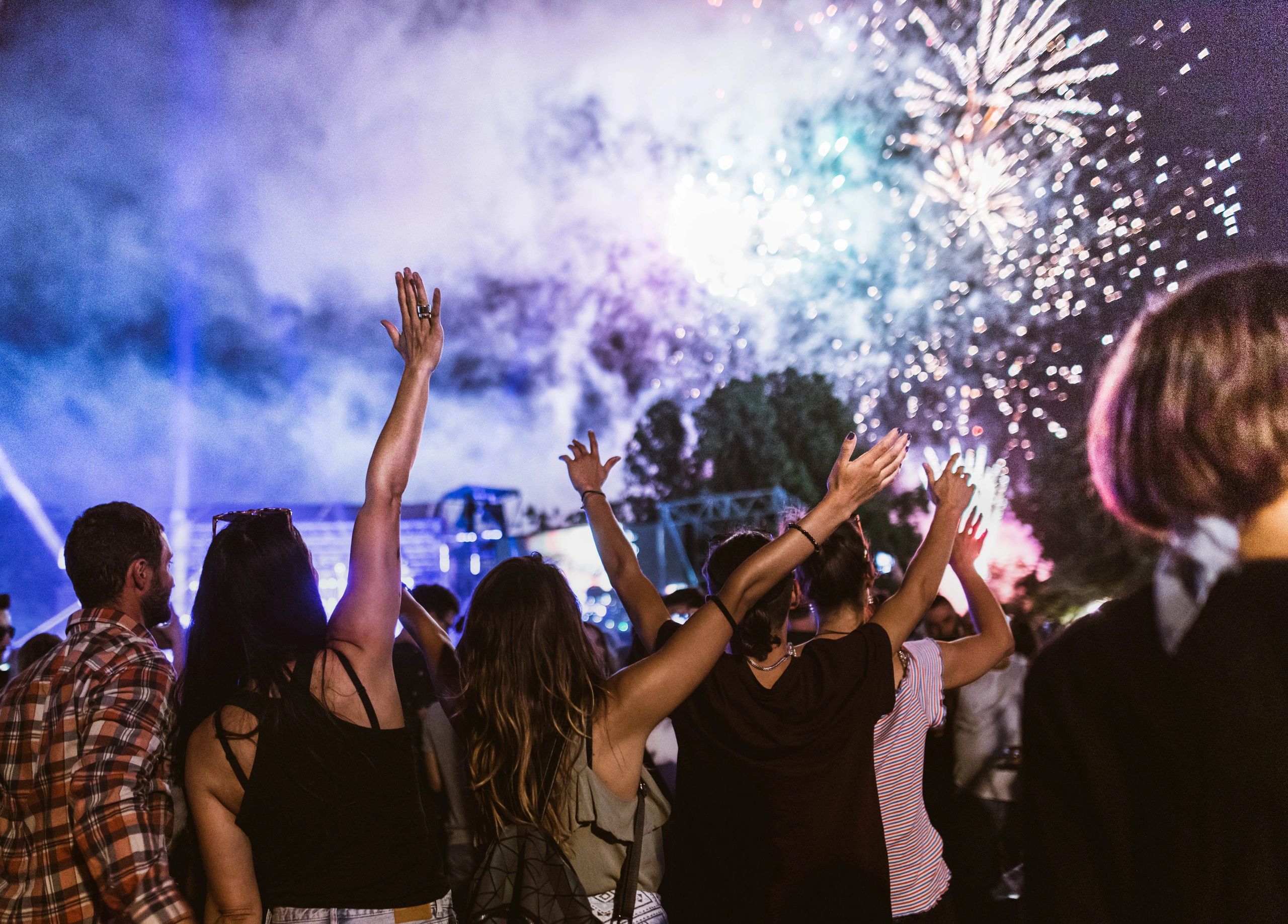 Audience gathered outdoors watching fireworks